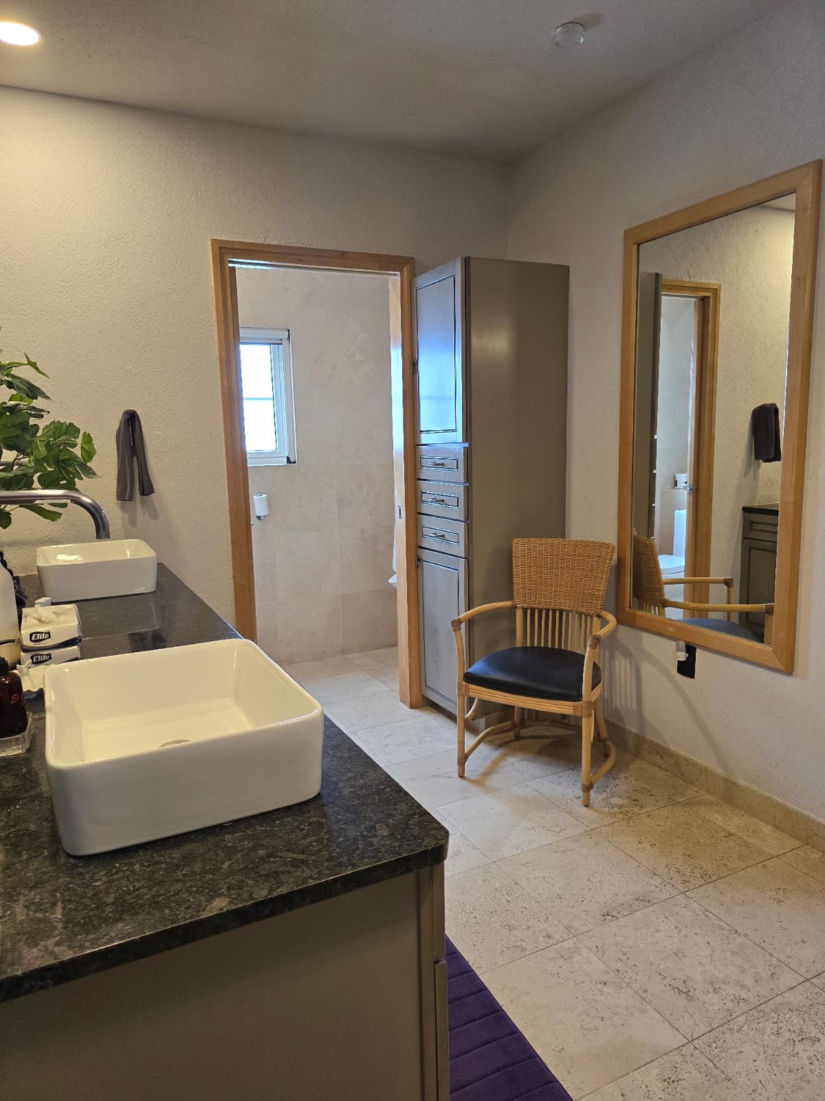 Bathroom with double vessel sinks and dark granite