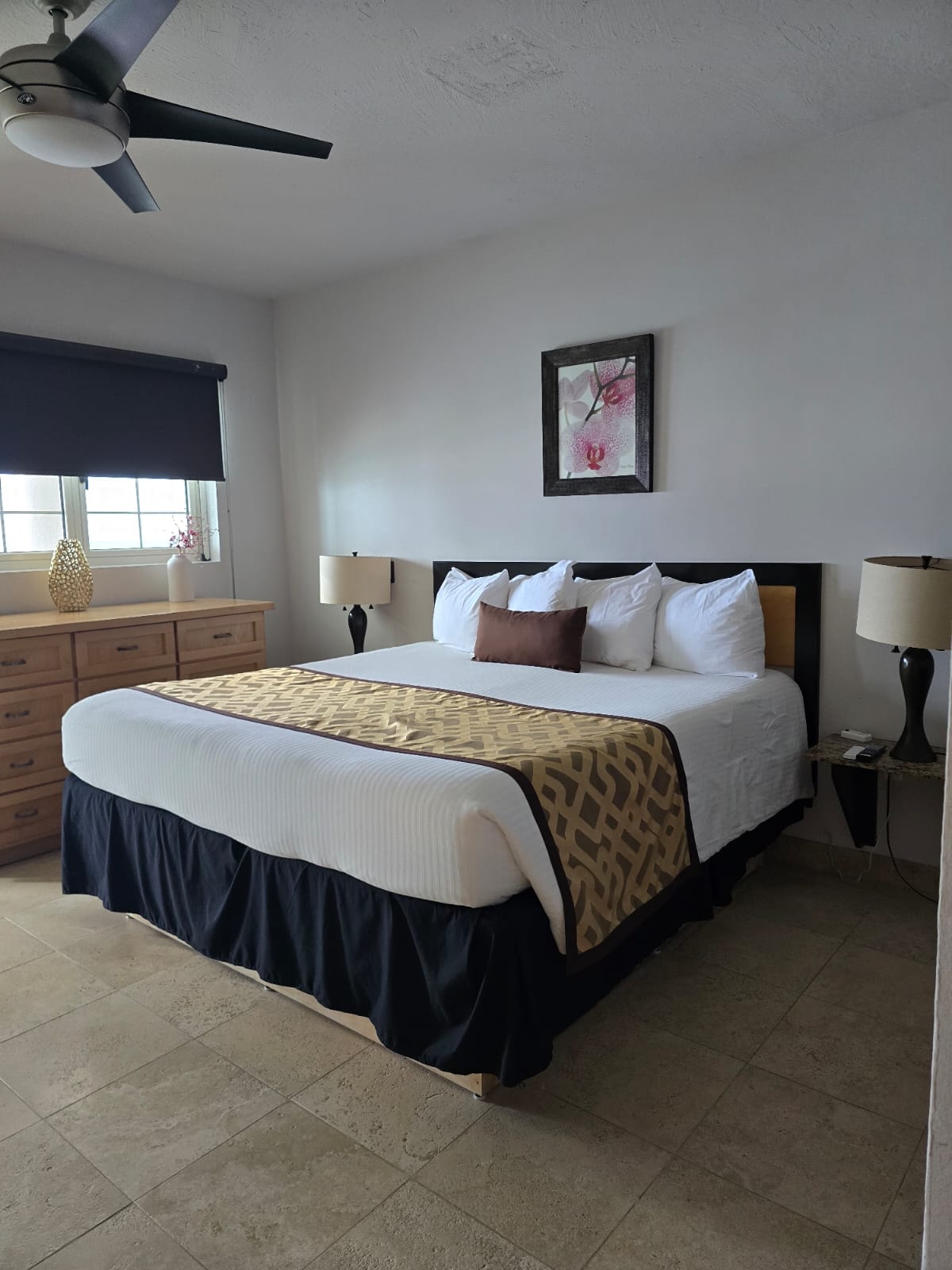 Master bedroom with dark headboard and gold bedding